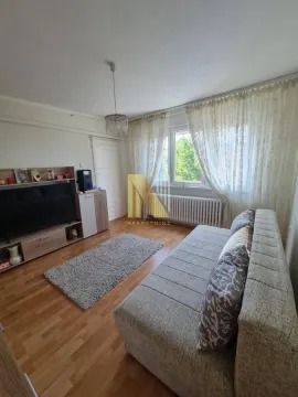 Dnevna soba sa garniturom, TV komodom i prozorom sa zavesama. - image 2