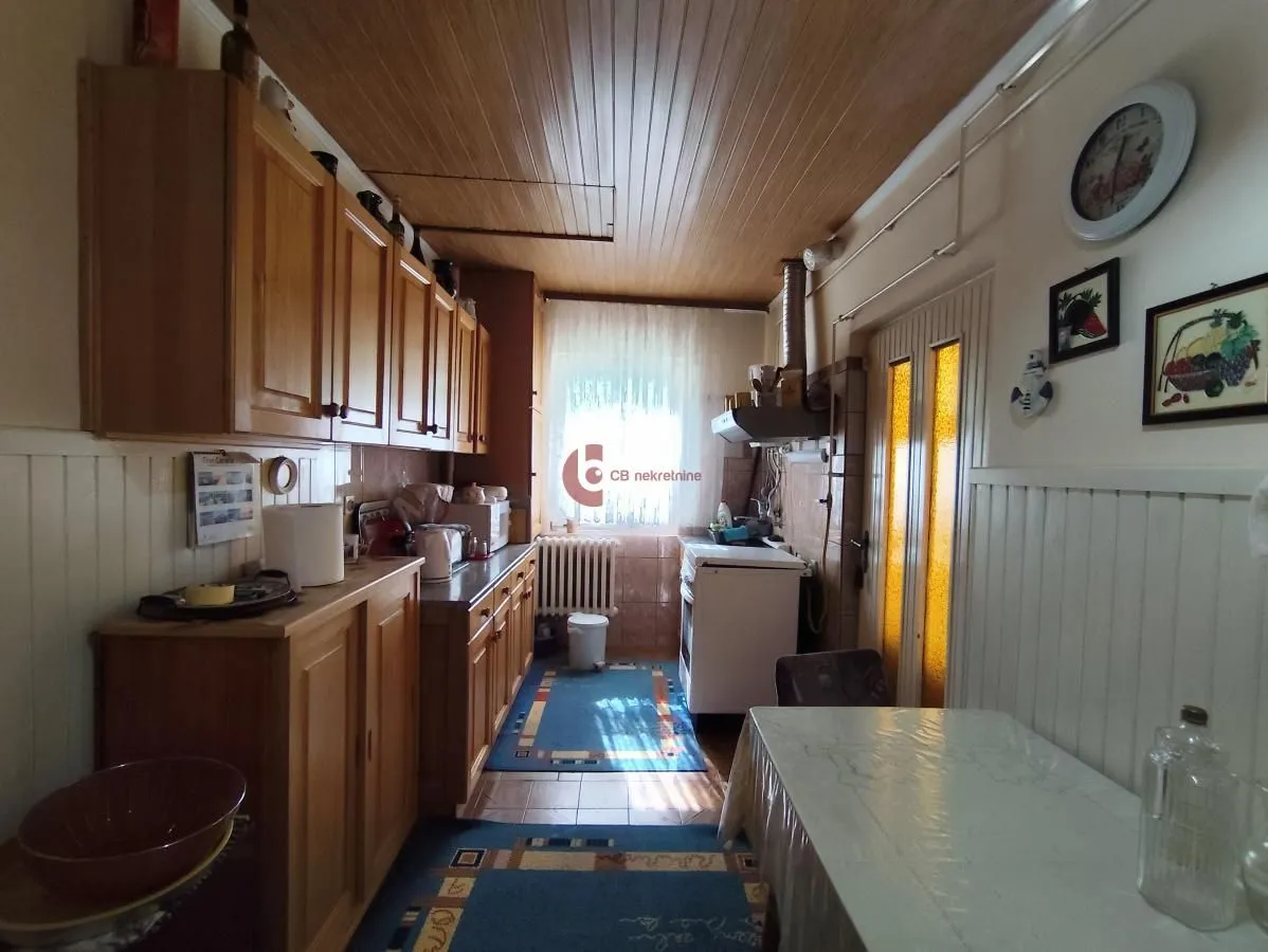 Small kitchen with wooden cabinetry and a dining table.