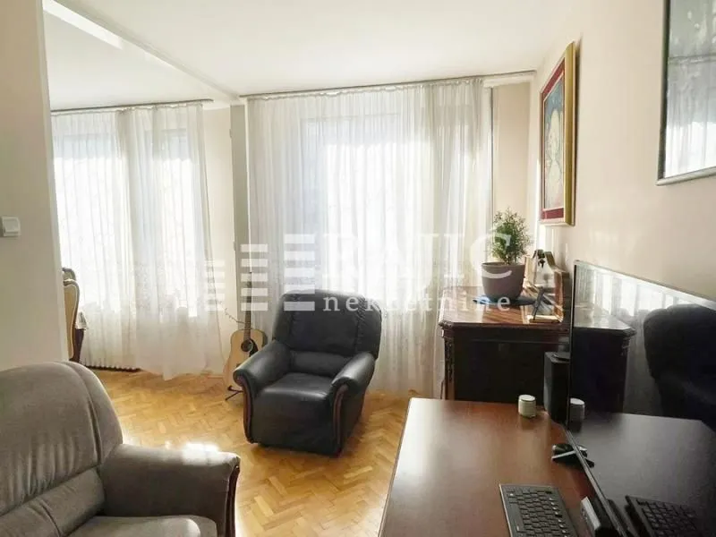 Living room with furniture and parquet flooring.