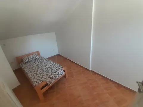Small bedroom with a bed and ceramic floor tiles. - image 18