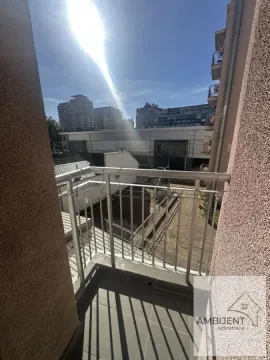 Manji balkon sa metalnom ogradom i pogledom na gradsko okruženje. - image 10