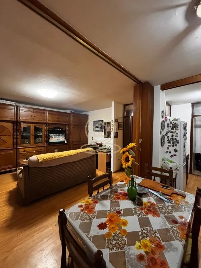 Living room with dining area and wooden furniture.