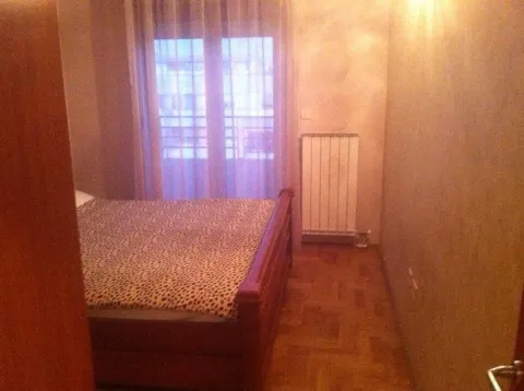 Spavaća soba sa drvenim krevetom i svijetlim zidovima. - image 7