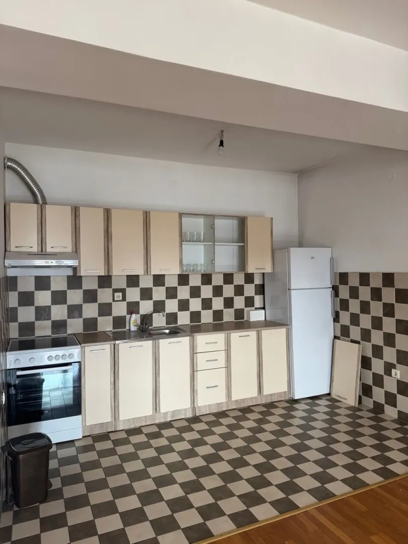 View of the kitchen with cabinets, a stove, and a refrigerator.