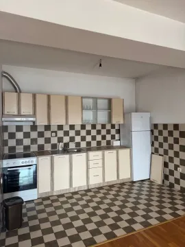 View of the kitchen with cabinets, a stove, and a refrigerator. - image 2