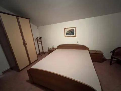 Simply furnished bedroom with a double bed and a wardrobe. - image 25