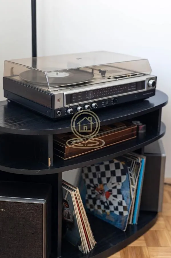 Old record player with vinyl records on a shelf indoors.