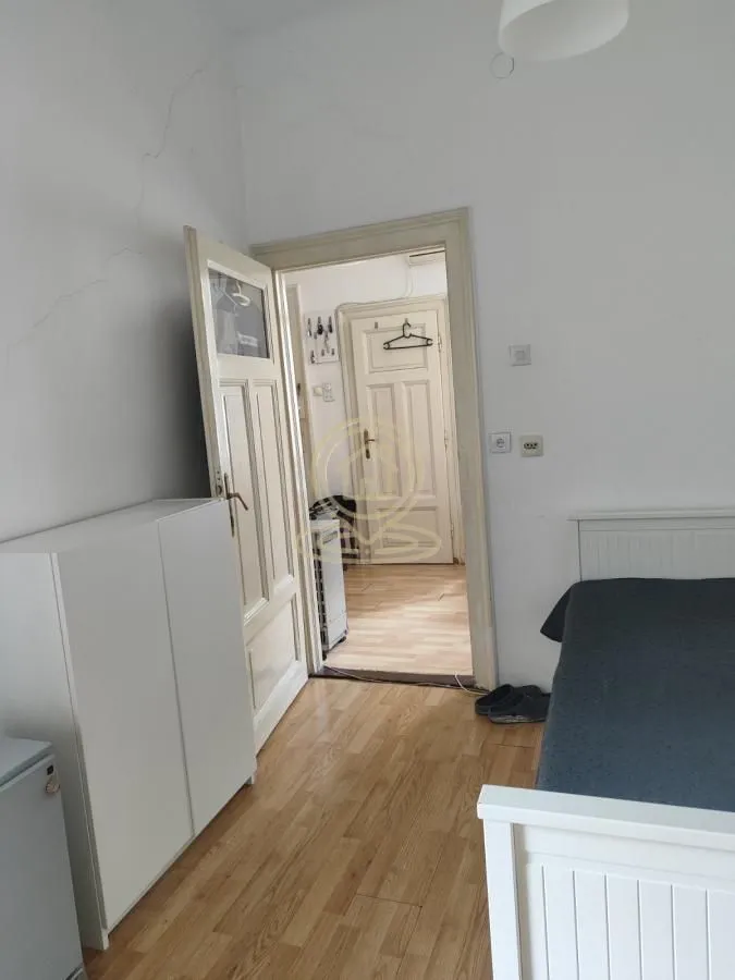 Furnished bedroom with a bed and wardrobe, overlooking the hallway.