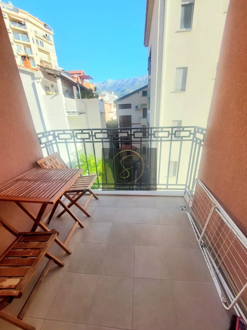 Furnished balcony with a wooden table and chairs and a view of the neighborhood.