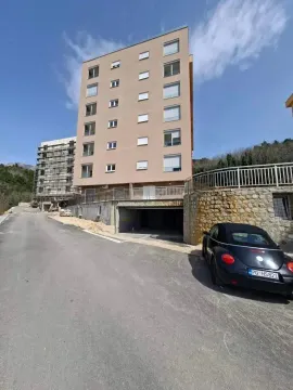 Pogled na spoljašnjost stambene zgrade i prilaz sa parkingom. - image 4