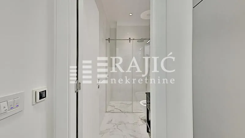 View of a modernly decorated bathroom with a walk-in shower.