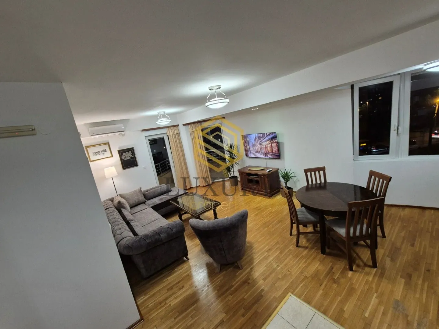 Spacious living room with a dining area and parquet flooring.