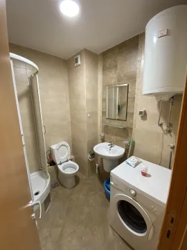 Bathroom with a shower cabin and washing machine. - image 12