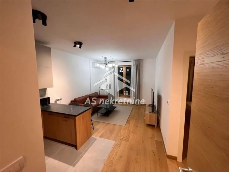Living room with kitchen and dining area in an open space layout.