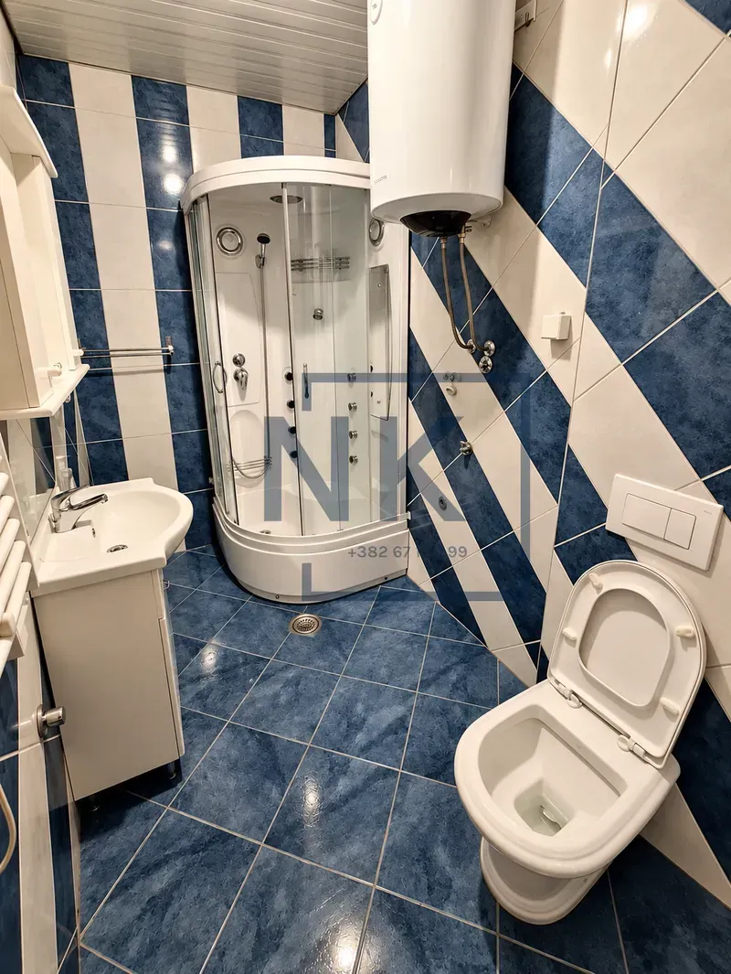 Kupatilo opremljeno tuš kabinom, umivaonikom i toaletom.