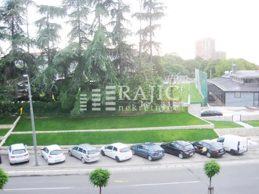 View from the terrace overlooking the yard and surrounding area with parked cars.