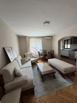 Living room with a sofa set and a dining area in the background.