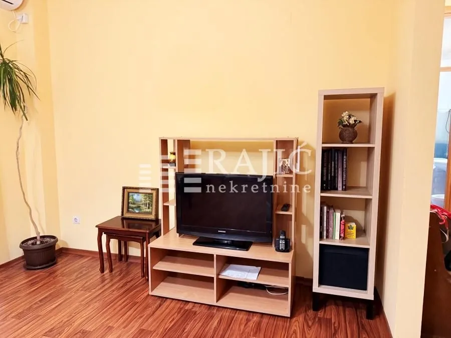 Living room with wooden furniture and a television.