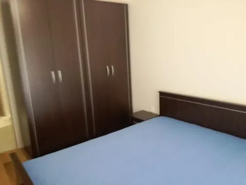 Bedroom with a double bed and a dark wooden wardrobe. - image 3