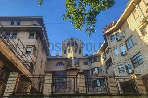 Pogled na spoljašnjost zgrade sa ogradom i drvećem. - image 15