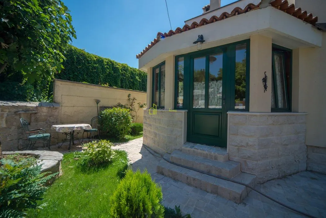 View of the house entrance with a yard and greenery.