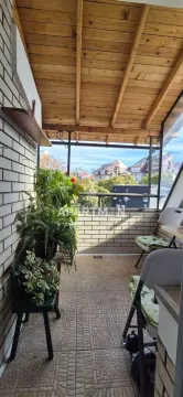 Covered balcony with a wooden ceiling structure and potted flowers. - image 5