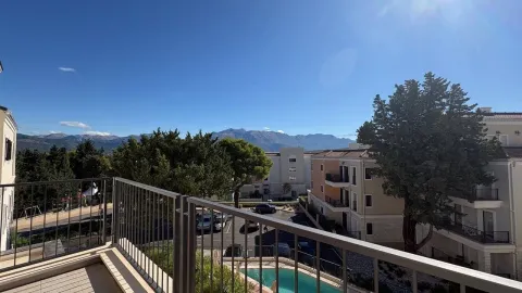 Pogled sa terase na okruženje zgrade, dvorište sa bazenom i planine u pozadini. - image 8