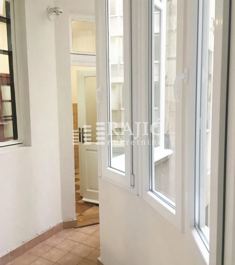 Enclosed balcony with white PVC windows and tiled floor.