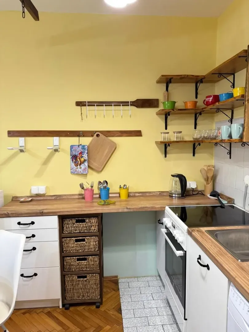 Small bright kitchen with wooden shelves and countertops.