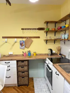Small bright kitchen with wooden shelves and countertops. - image 6