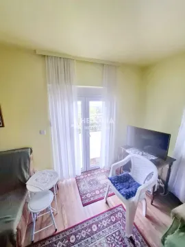 Dnevna soba sa garniturom, televizorom i izlazom na terasu. - image 11