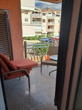 Furnished balcony with seating set and a view of surrounding buildings. - image 2