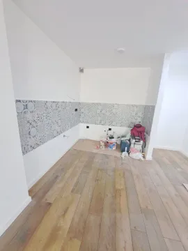 Nezavršeni prostor sa keramičkim pločicama na zidu i drvenim podom. - image 4