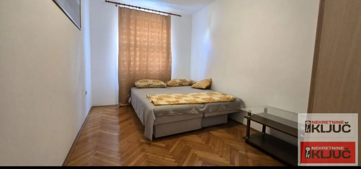 Bedroom with a double bed and parquet flooring.