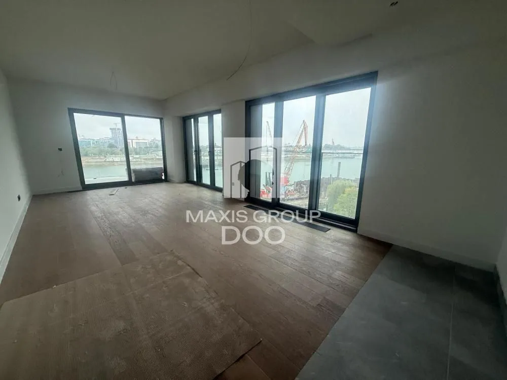 Empty unfinished room with large glass surfaces and river view.