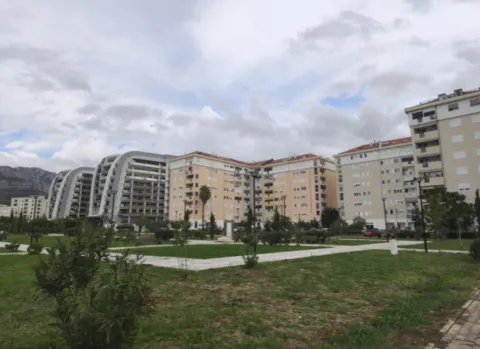 Pogled na stambene zgrade i uređen park ispred objekta. - image 2
