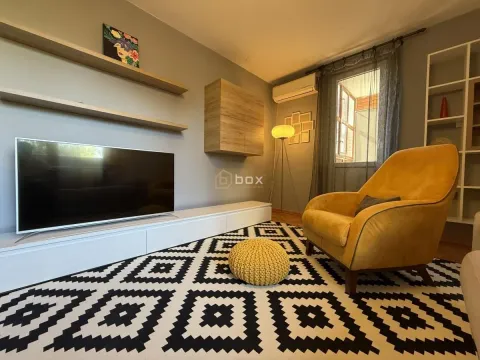 Living room with a TV, a yellow armchair, and wall shelves. - image 2