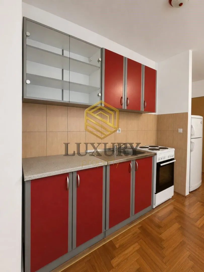 Kitchen with red cabinets, a sink, and a stove.