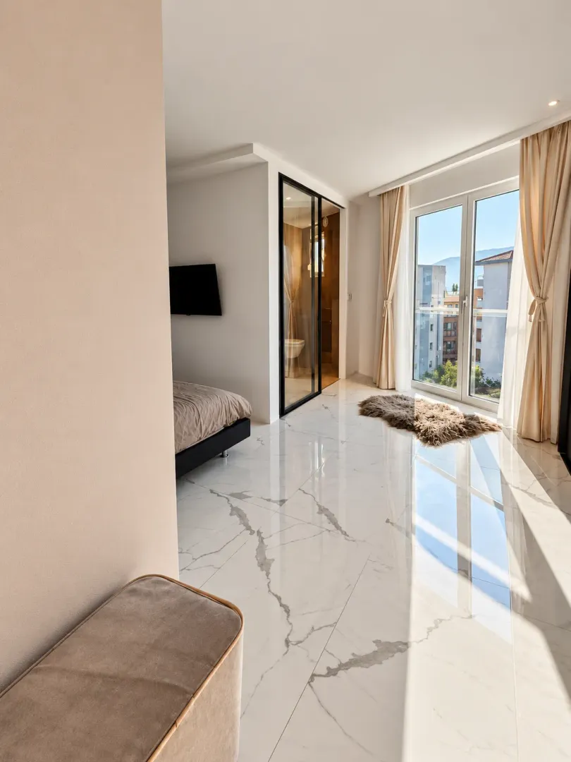 Modern bedroom with a large window and city view.