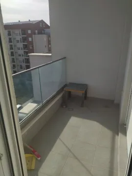 Pogled na prostrani i svijetli balkon sa staklenom ogradom i pogledom na okolne zgrade. - image 5
