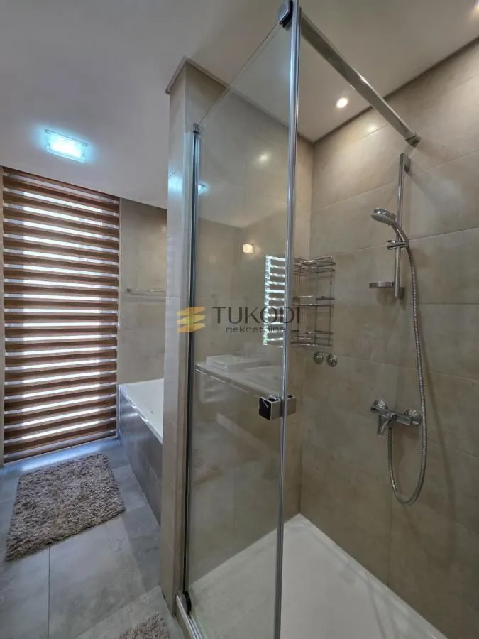 Bathroom with a shower cabin and a bathtub.