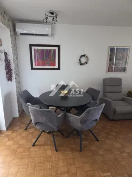 Trpezarija sa okruglim stolom i tapaciranim stolicama u sklopu dnevnog boravka. - image 2