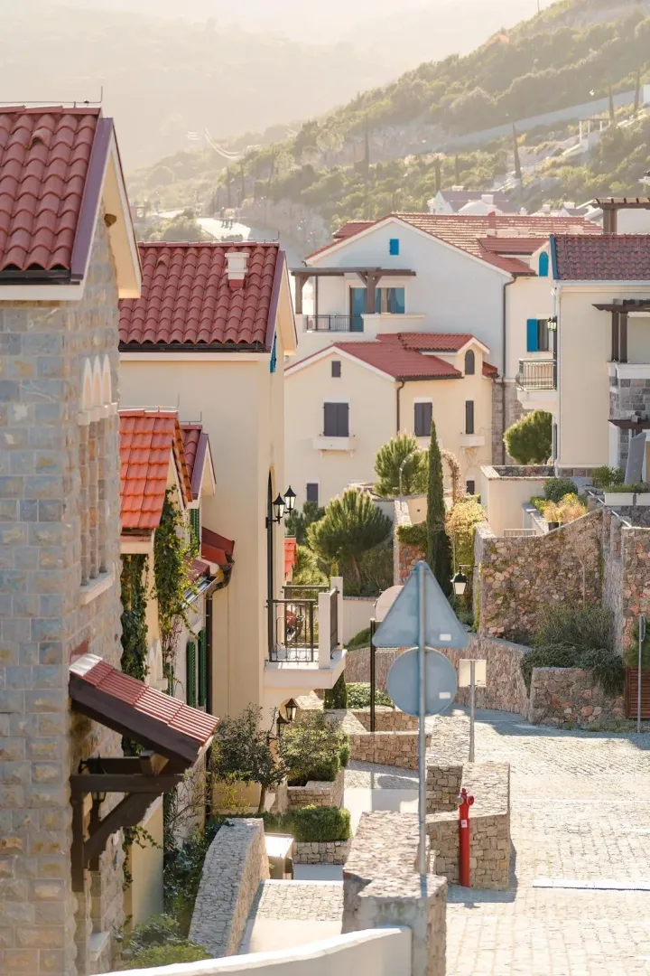 Pogled na mediteranski kompleks zgrada sa kamenim detaljima i krovovima od crvenog crijeva.
