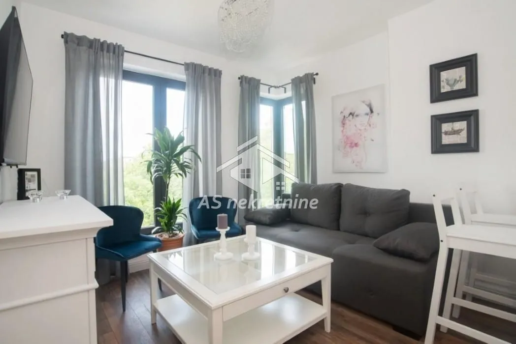 Living room with a sofa, coffee table, and a large window.