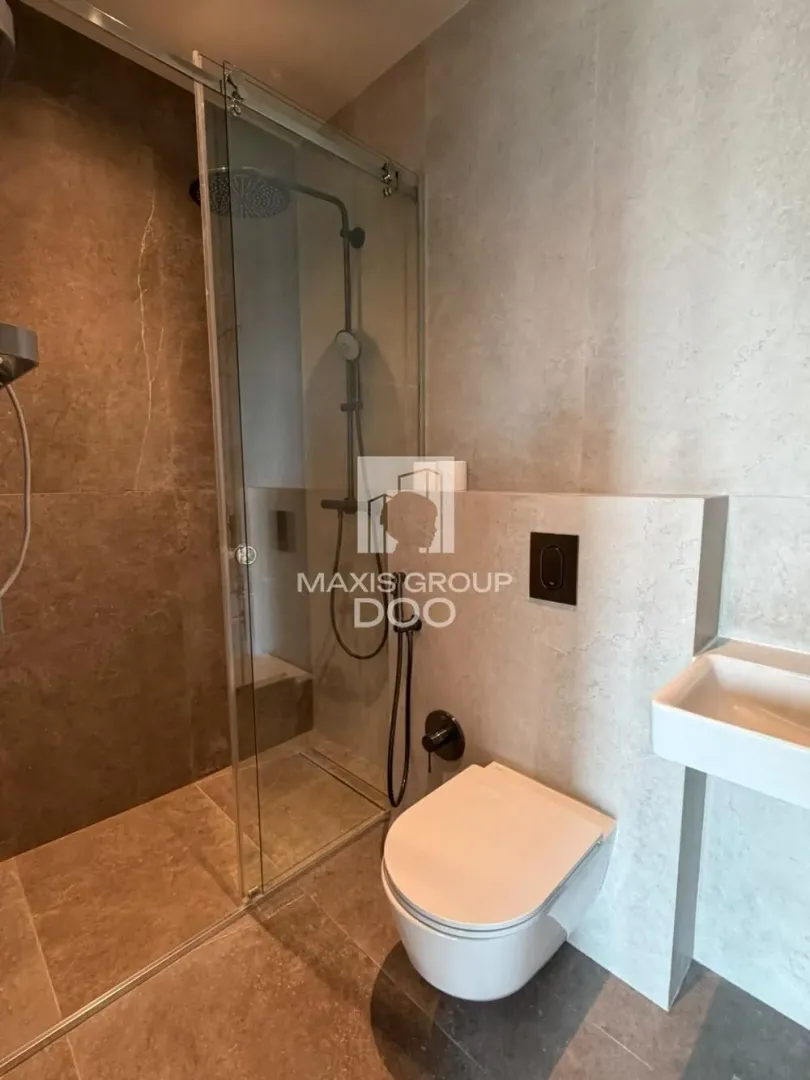Moderno kupatilo sa tuš kabinom, WC šoljom i umivaonikom.