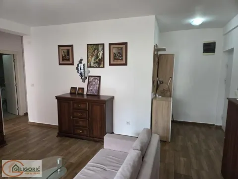 Living room with a sofa, chest of drawers, and paintings on the wall. - image 7