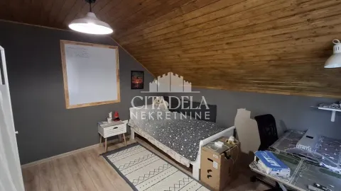 Potkrovna spavaća soba sa krevetom i radnim stolom. - image 14