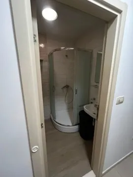 Pogled iz hodnika na kupatilo sa tuš kabinom i umivaonikom. - image 8