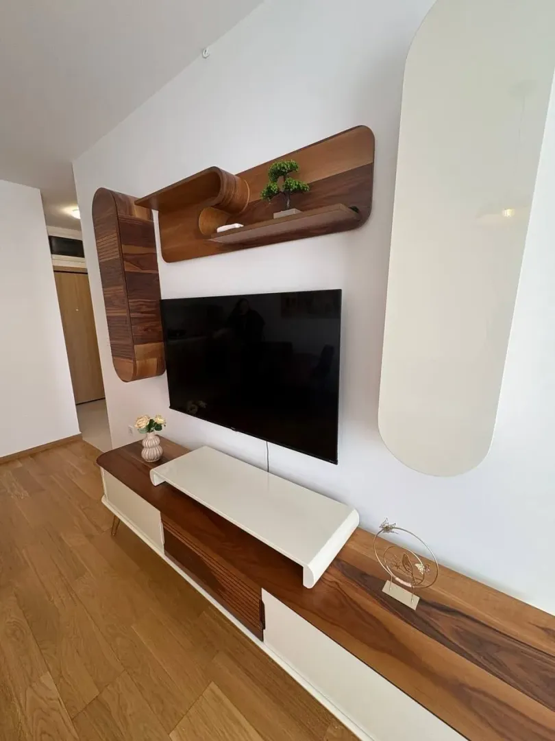 Dnevna soba sa TV policom i modernim namještajem.