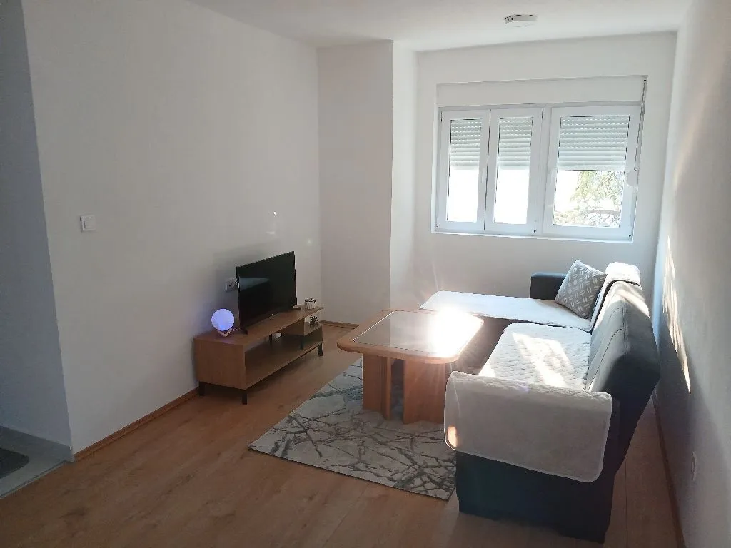 Bright living room with a sofa set and a television.
